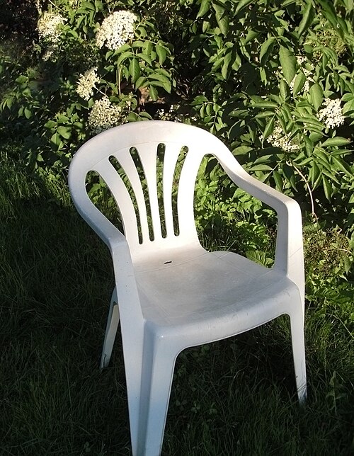 Chaise Monobloc blanche en plastique dans un jardin